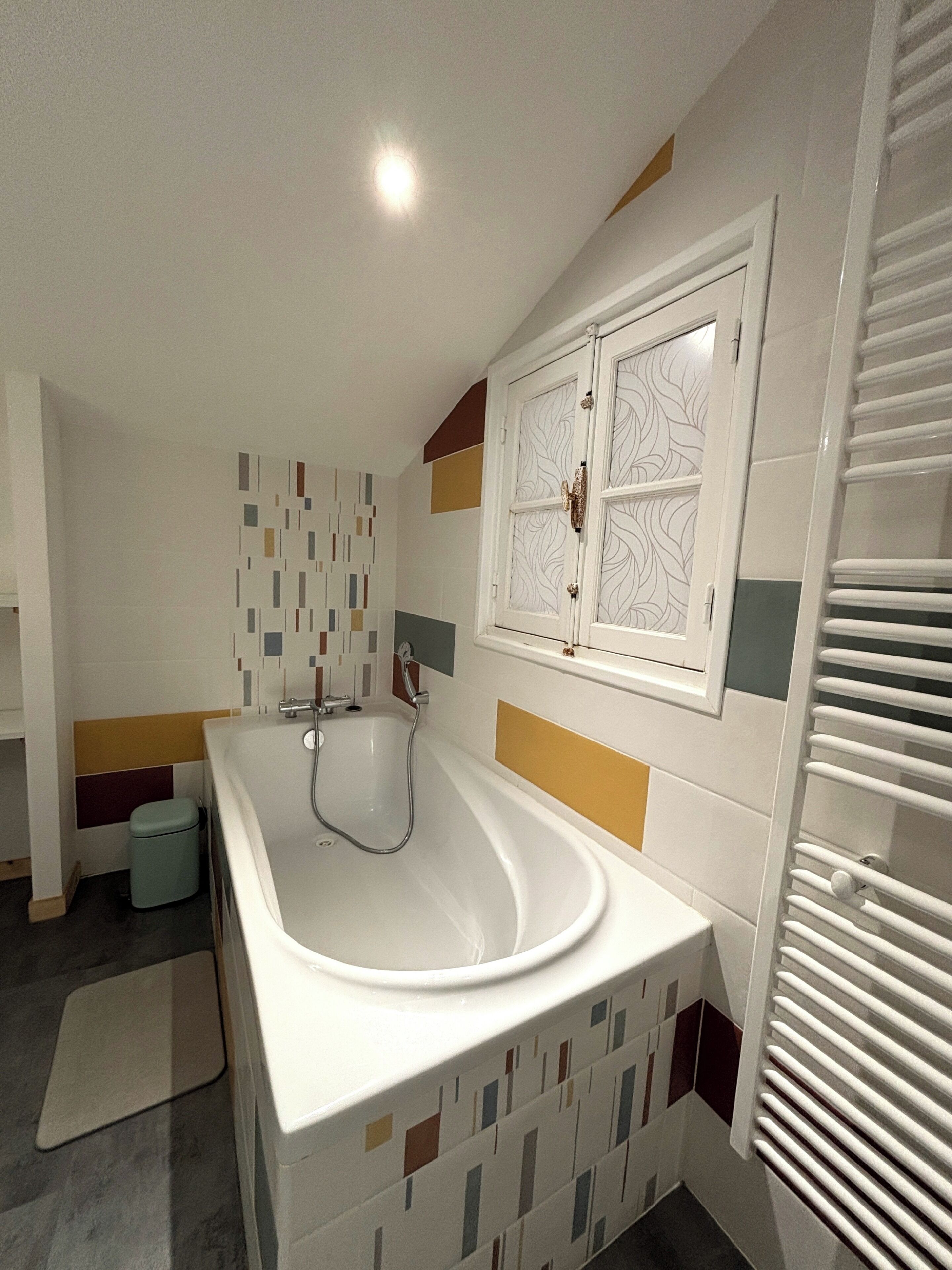 A modern bathroom with a freestanding bathtub, a toilet, and a shower area.