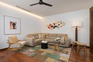 A living room with a sofa, armchair, coffee table, and floor lamp.