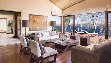 Un salón amplio con un gran ventanal que ofrece una vista panorámica, un rincón de descanso acogedor y un diseño moderno.