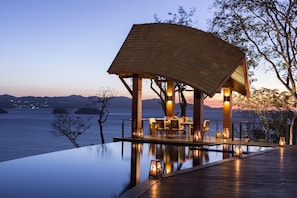 An infinity pool with a wooden deck and a covered seating area overlooking a body of water. - Four Seasons Resort Costa Rica At Peninsula Papaga (Nacascolo)