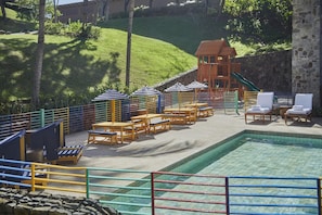 A pool area with lounge chairs, umbrellas, and a small building with a red roof. - Four Seasons Resort Costa Rica At Peninsula Papaga (Nacascolo)