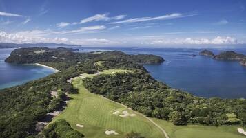 A golf course with a clear view of the surrounding water and islands.