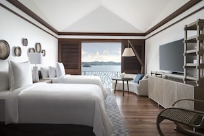 A hotel room with a bed, a sofa, a TV, and a view of the sea. - Four Seasons Resort Costa Rica At Peninsula Papaga (Nacascolo)
