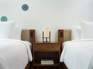 A hotel room with two beds, a nightstand, a lamp, and two decorative wall plates. - Four Seasons Resort Costa Rica At Peninsula Papaga (Nacascolo)