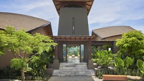 A modern building with a central entrance, surrounded by lush greenery and a paved area. - Four Seasons Resort Costa Rica At Peninsula Papaga (Nacascolo)