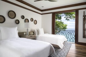 A bedroom with two beds, a ceiling fan, and a view of the sea through a balcony. - Four Seasons Resort Costa Rica At Peninsula Papaga (Nacascolo)
