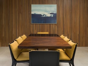A conference room with a wooden panel wall, a large table, and yellow upholstered chairs. - Four Seasons Resort Costa Rica At Peninsula Papaga (Nacascolo)