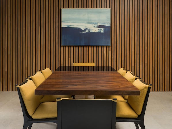 A conference room with a wooden panel wall, a large table, and yellow upholstered chairs. - Four Seasons Resort Costa Rica At Peninsula Papaga (Nacascolo)