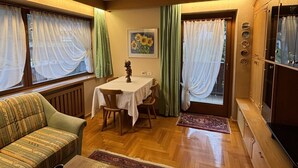 A cozy living room with a sofa, a dining table, and a TV cabinet. - Ciasa Nives (Badia)