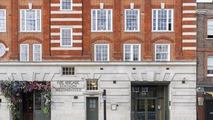 A fire brigade station with a sign reading "Fire Brigade Station Westminster" and a door with a green entrance. - Westminster Fire Station Comfort Apartments (London)