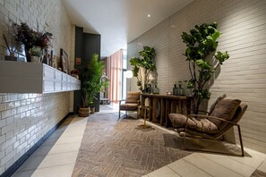 Ein modernes Interieur mit Fischgrätparkett, einem Holzesstisch und einer gemütlichen Sitzecke.