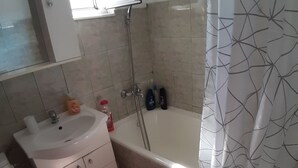 Une salle de bain avec un lavabo, des toilettes et une baignoire.