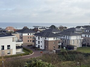 Ein Wohngebiet mit modernen Häusern, einer gepflasterten Auffahrt und Blick auf das Meer.