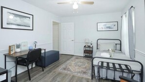 A bedroom with a bed, desk, chair, and a ceiling fan. - La Casa De Francella (Harris County)