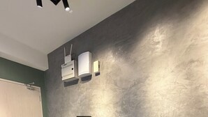 Un comedor moderno con una mesa oscura, dos sillas grises y una taza blanca.