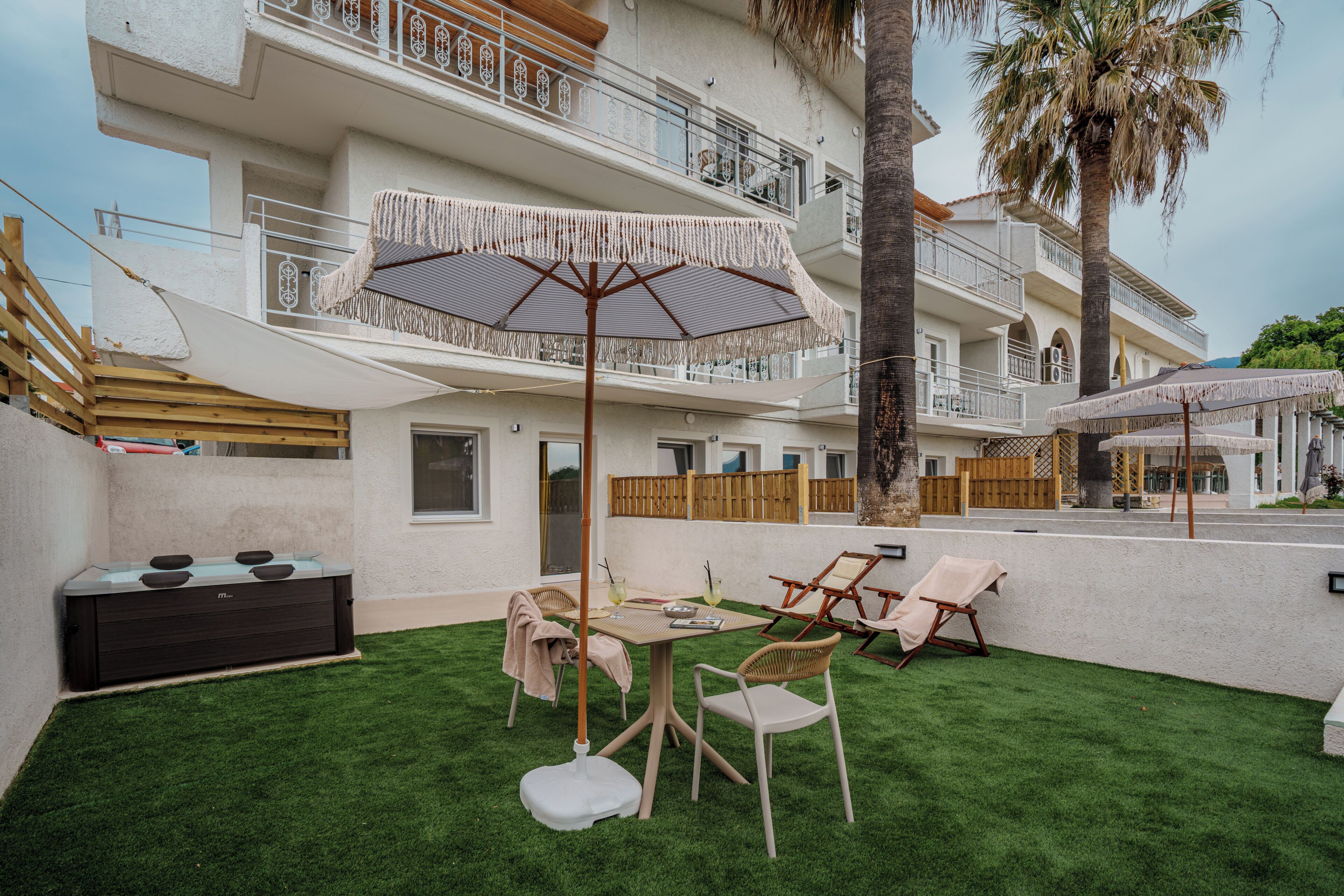 A patio with a table, chairs, and a large umbrella.