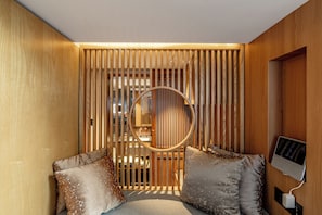A room with a wooden slat partition, a circular mirror, and a bed with pillows. - The JOY courtyard Beijing near Tiananmen Forbidden City (Beijing)