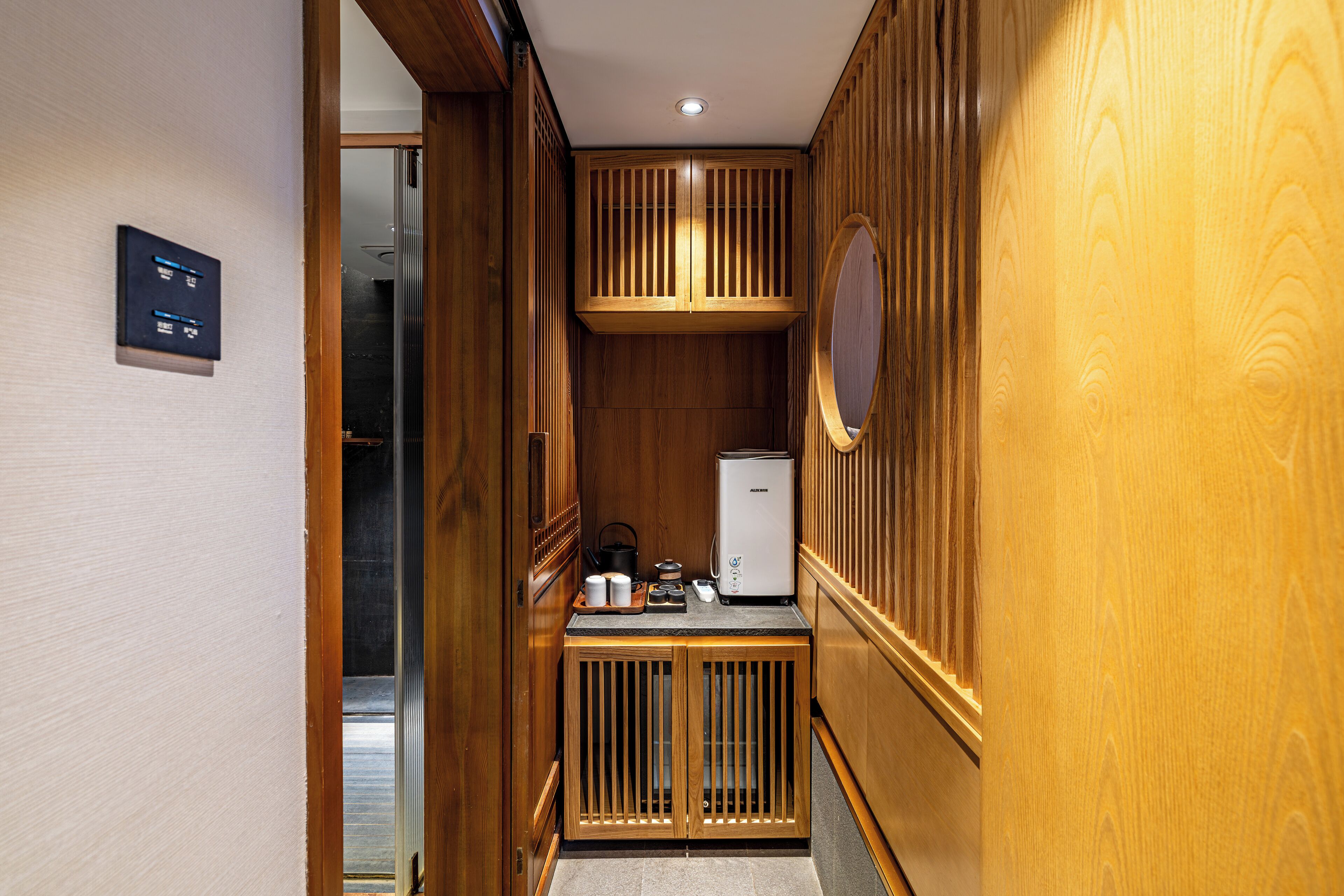 A compact kitchen with wooden cabinetry, a built-in refrigerator, and a small countertop with kitchenware.
