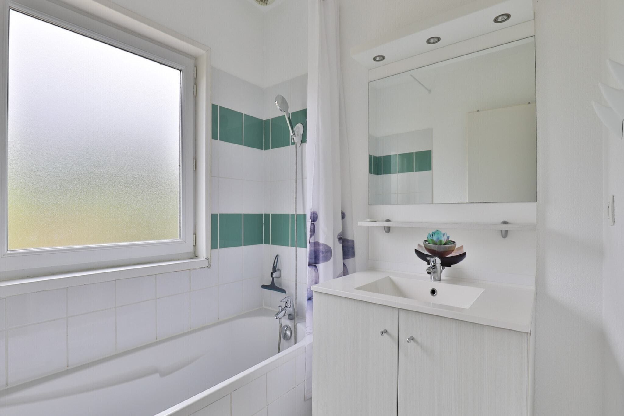 Een moderne badkamer met een bad, een douche, een wastafel en een spiegel.