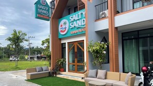 Hotel 'Salty Sand Krabi Hotel' met een modern uiterlijk, een terras en een zichtbare motor.
