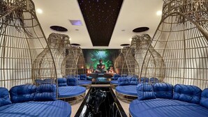Una stanza con zone salotto circolari, una statua centrale di Buddha e un soffitto decorato con stelle.