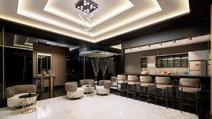 Un interno moderno con un'area bar, posti a sedere e una cucina.