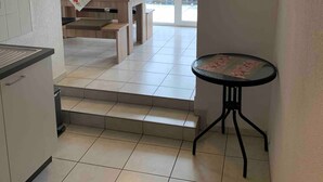 Una cocina con comedor, una mesa pequeña y vistas al exterior.