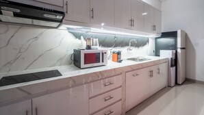 A modern kitchen with a built-in microwave, a kettle, and a refrigerator. - Luxury minimalist villa The Toy (Kerobokan)