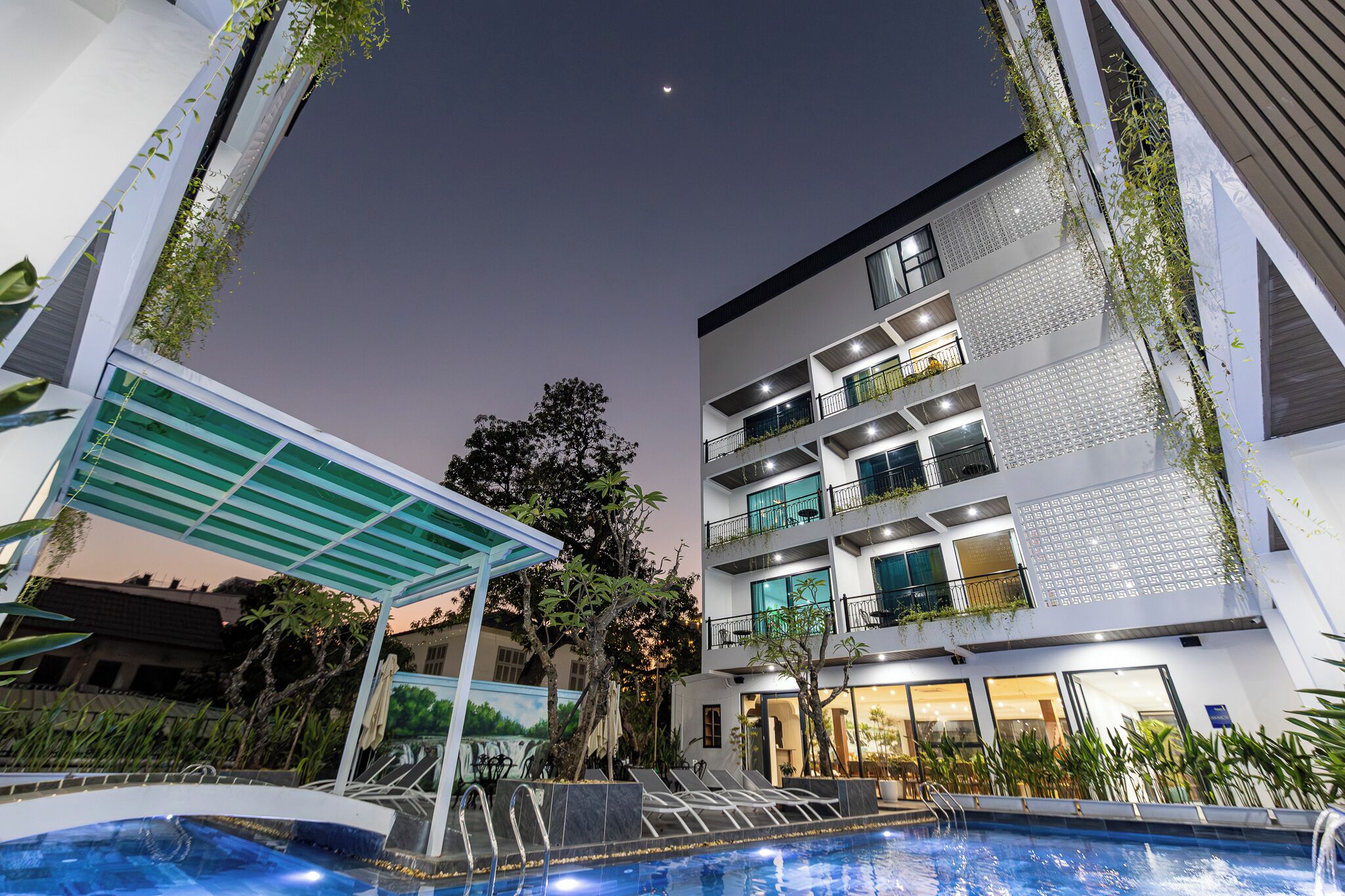 Hotel modern amb piscina, zona d'estar a l'exterior i espai cobert.