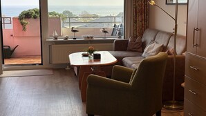 A cozy living room with a view of the sea, a dining table, and a sofa. - Fantastic view over the Baltic Sea as far as the horizon! (Dahme)