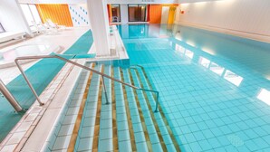 A swimming pool with clear blue tiles, a metal handrail, and a tiled floor. - Fantastic view over the Baltic Sea as far as the horizon! (Dahme)