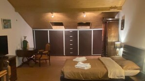 Een slaapkamer met een bed, bureau, stoel en garderobe.