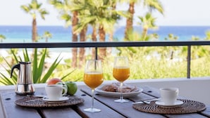 A table with a coffee pot, two glasses of orange juice, and a plate of pastries on a balcony overlooking the ocean. - Amazing Sea views # Macenas Resort # 2BR # Sunbeds (Mojácar)