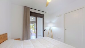 A hotel room with a bed, a lamp, a door, and a view of the outdoors. - Amazing Sea views # Macenas Resort # 2BR # Sunbeds (Mojácar)