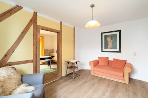 Une pièce avec un plafond en bois, un canapé, une chaise et une table.