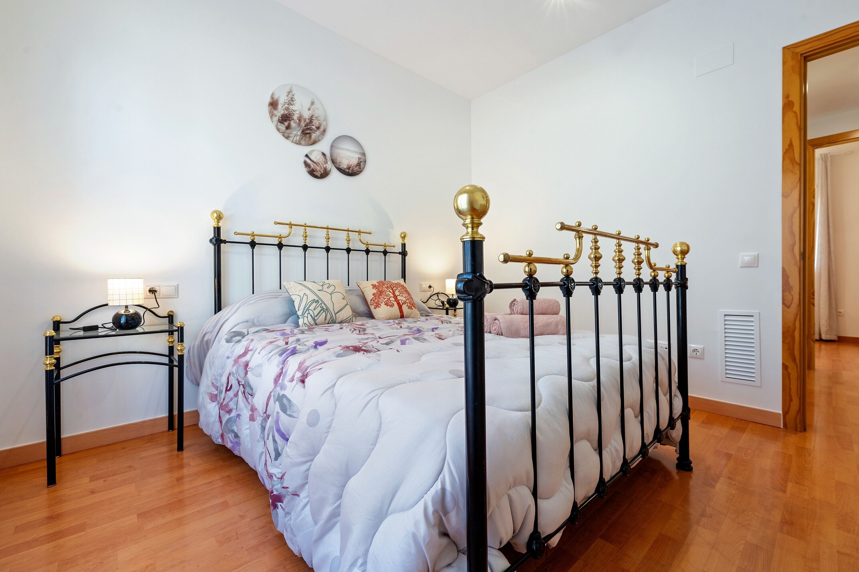 Ein Schlafzimmer mit Bett, Nachttischen und Wandbildern.