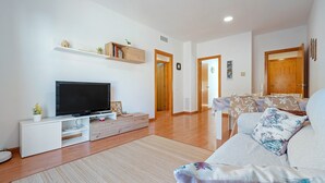 A living room with a flat-screen TV, a sofa, a coffee table, and a bookshelf. - Apartment 'Ángel' with Private Terrace, Wi-Fi and Air Conditioning (Vinebre)