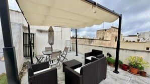 A rooftop patio with outdoor furniture, a table, and a canopy. - Apartment 'Gabriele  Salento' with Private Terrace, Wi-Fi and Air Conditioning (Gallipoli)