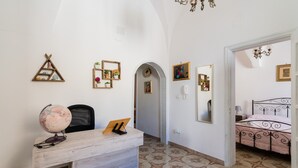 A room with a desk, a globe, a bed, and a mirror. - Apartment 'Gabriele  Salento' with Private Terrace, Wi-Fi and Air Conditioning (Gallipoli)