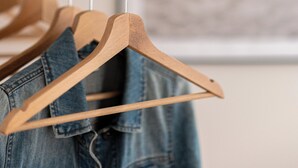 Un perchero de madera con una chaqueta vaquera colgada.
