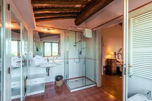 Une salle de bain avec une douche à parois de verre, un lavabo et un miroir.