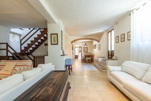 Un grand espace de vie comprenant un escalier, un coin repas et un canapé.