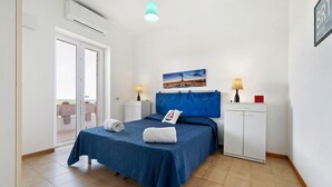 A bedroom with a bed, a nightstand, a lamp, a painting, and a wardrobe. - Villa 'La Dimora di Patty' with Sea View, Wi-Fi and Air Conditioning (San Cataldo)