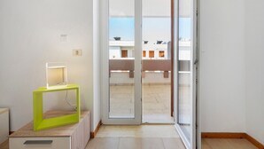 A room with a sliding glass door leading to an outdoor balcony, a small table with a lamp, and a wooden floor. - Villa 'La Dimora di Patty' with Sea View, Wi-Fi and Air Conditioning (San Cataldo)