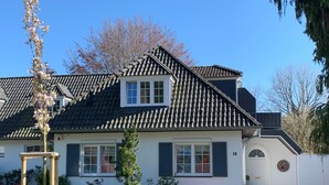 A house with a tiled roof, white walls, and a number '28' on the door. - Holiday Home 'Feel at Home in Different Spaces' with Wi-Fi (Heide)