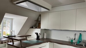 A modern kitchen with white cabinets, a countertop, and a window. - Holiday Home 'Feel at Home in Different Spaces' with Wi-Fi (Heide)