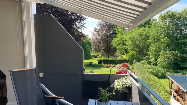 A balcony with a table, chairs, and a potted plant. - Holiday Home 'Feel at Home in Different Spaces' with Wi-Fi (Heide)