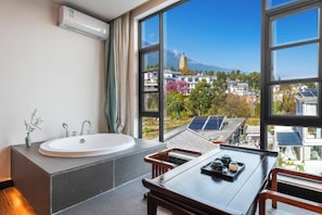 Une salle de bain moderne avec une grande fenêtre, un lavabo et une table avec des chaises.