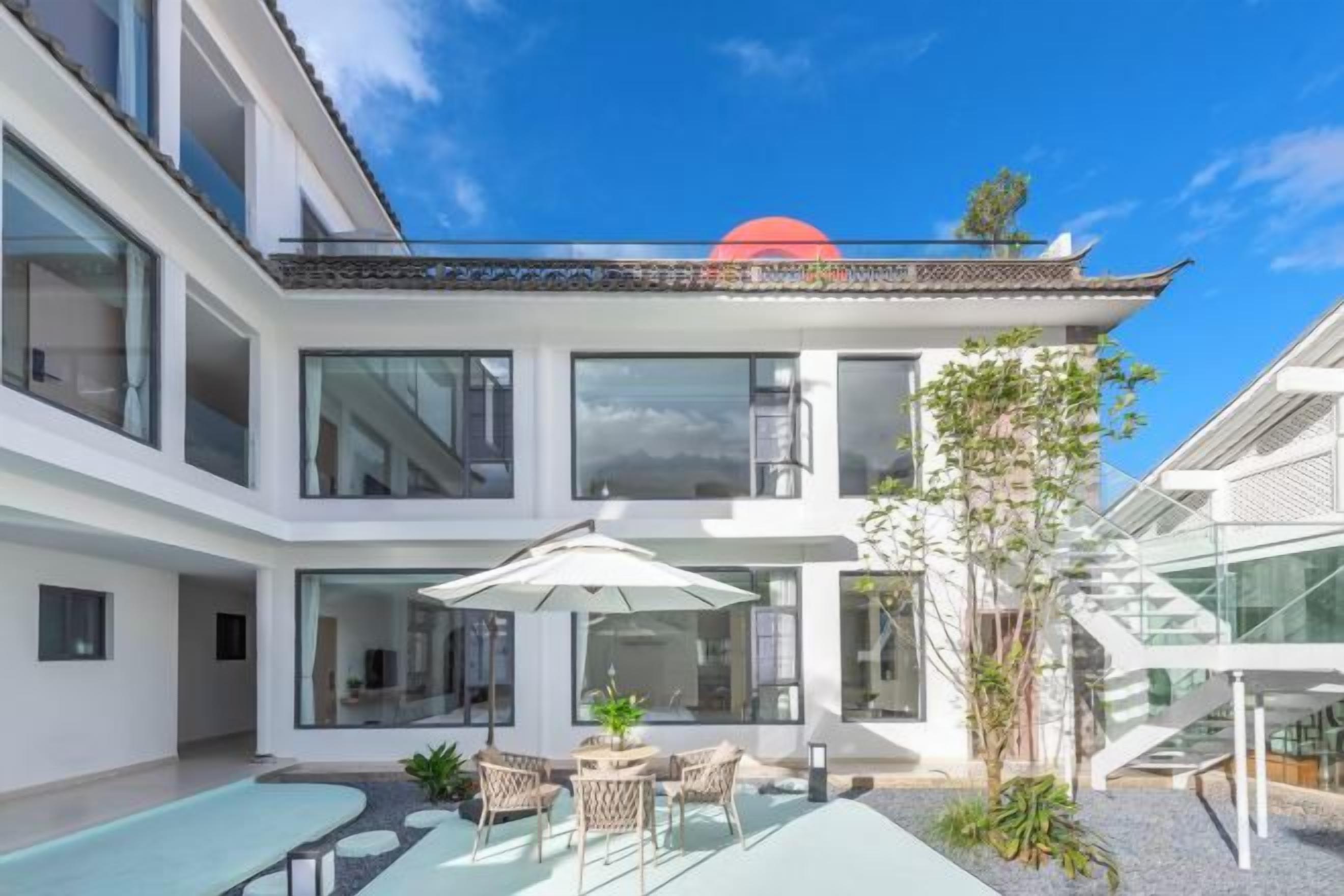 A modern multi-story building with a courtyard, outdoor seating, and a staircase.