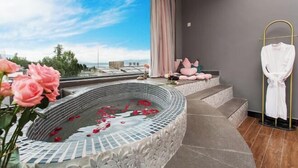 A modern bathroom with a large bathtub, a view of the sea, and a robe rack. - First Sight Yingshan Resort (Dali)